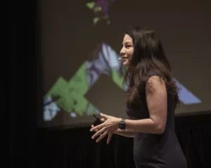Allison Shapira demonstrating how to close a presentation powerfully during a keynote on stage.