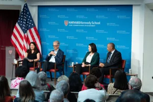 Panel discussion at Harvard Kennedy School with four speakers seated on stage in front of an audience