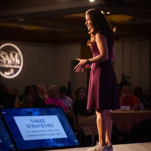 Allison Shapira delivering a keynote presentation to a live audience, demonstrating the power of human connection and audience engagement at conferences.