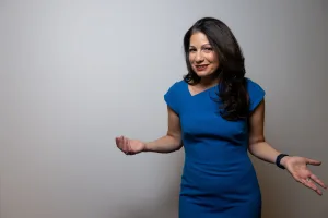 Speaker (Allison Shapira) in blue dress presenting about strategic authenticity and leadership 