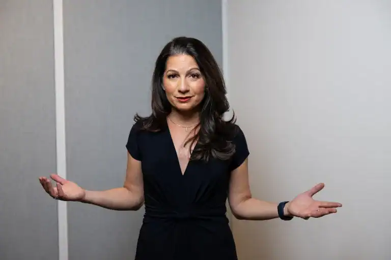 Keynote speaker and advisor, Allison Shapira speaking with open hand gesture, demonstrating confident and authentic leadership communication