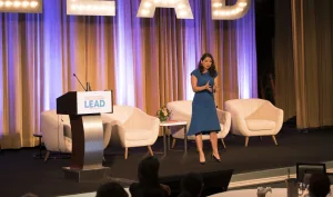 Allison Shapira delivering a keynote presentation on leadership communication at a conference.