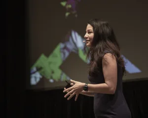 Allison Shapira speaking on stage during a keynote presentation.